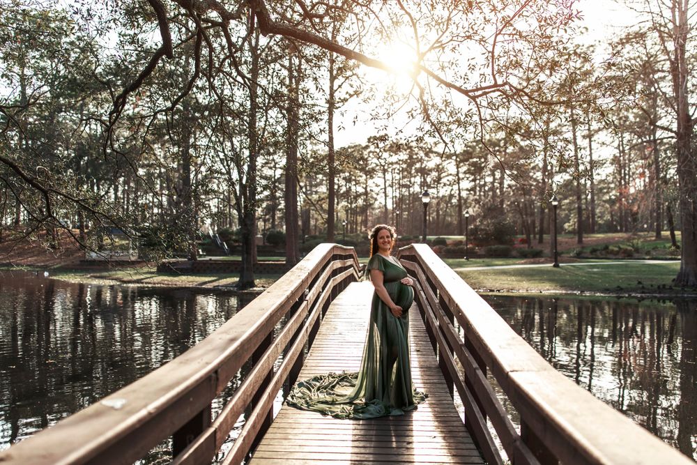 Wooden boardwalk stretches over tranquil cypress swamp at sunset.