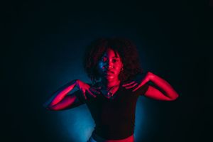 Dramatic portraits with moody red and blue lighting creating artistic silhouettes.