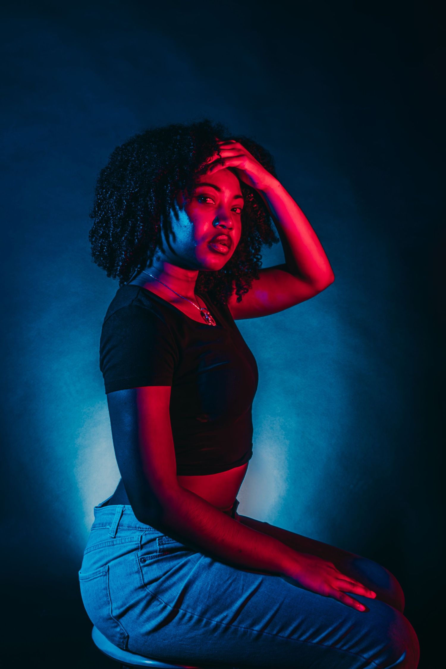 Dramatic portrait against blue and red lighting with dynamic poses showing emotion and movement.