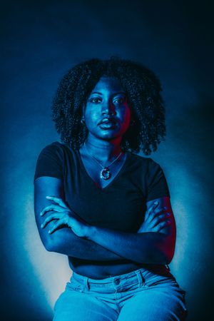 Modern portrait series with bold color lighting and confident poses against dark background.