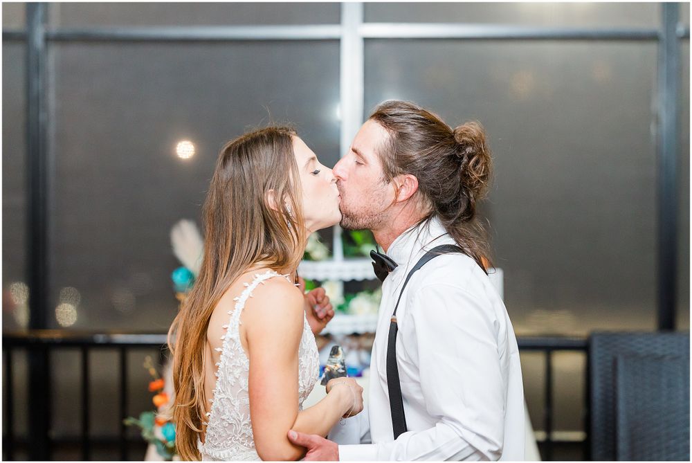 A wedding couple sharing a romantic kiss during their celebration.