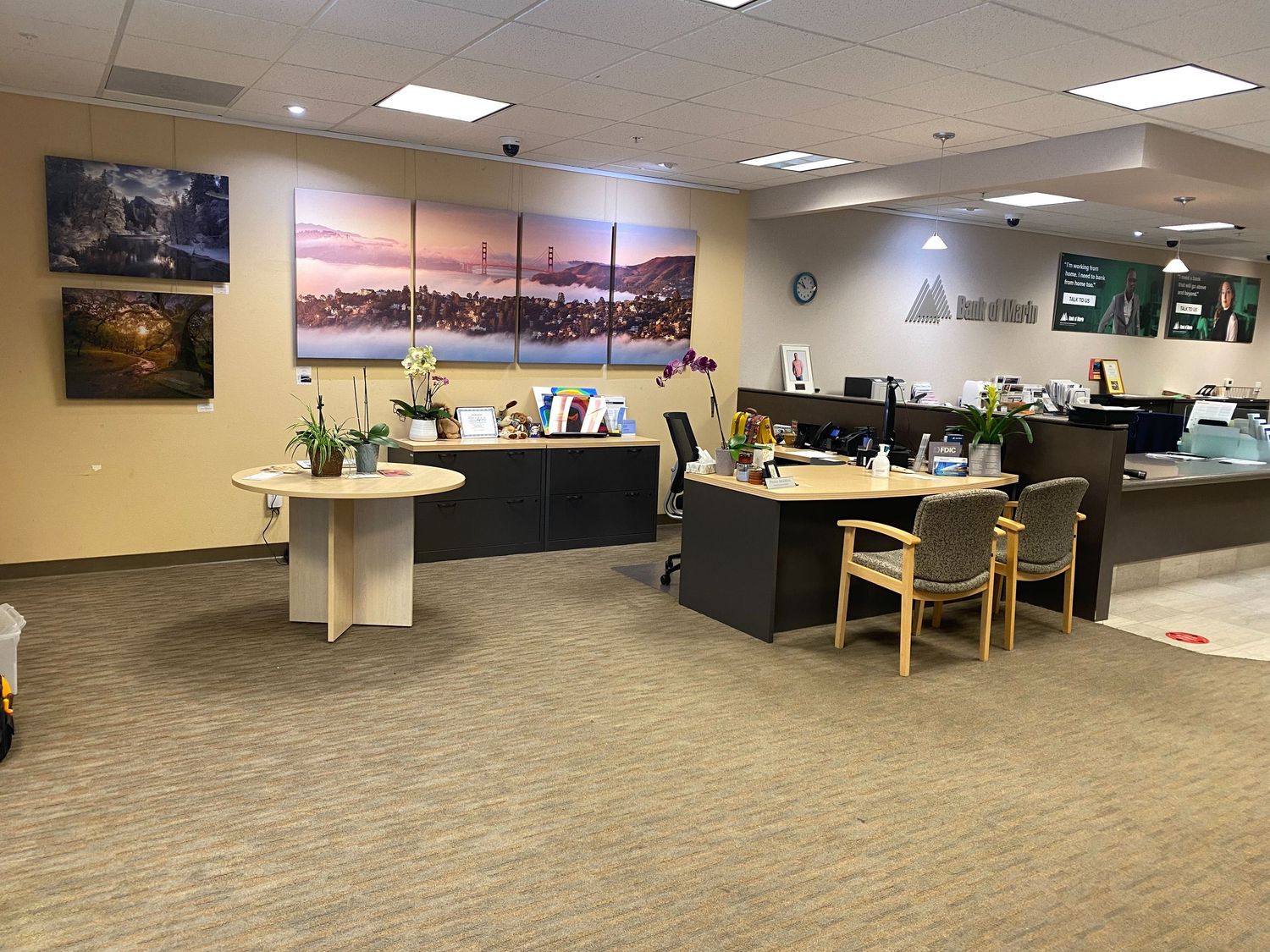 Modern office space with landscape photography displayed on walls and contemporary desk arrangements.