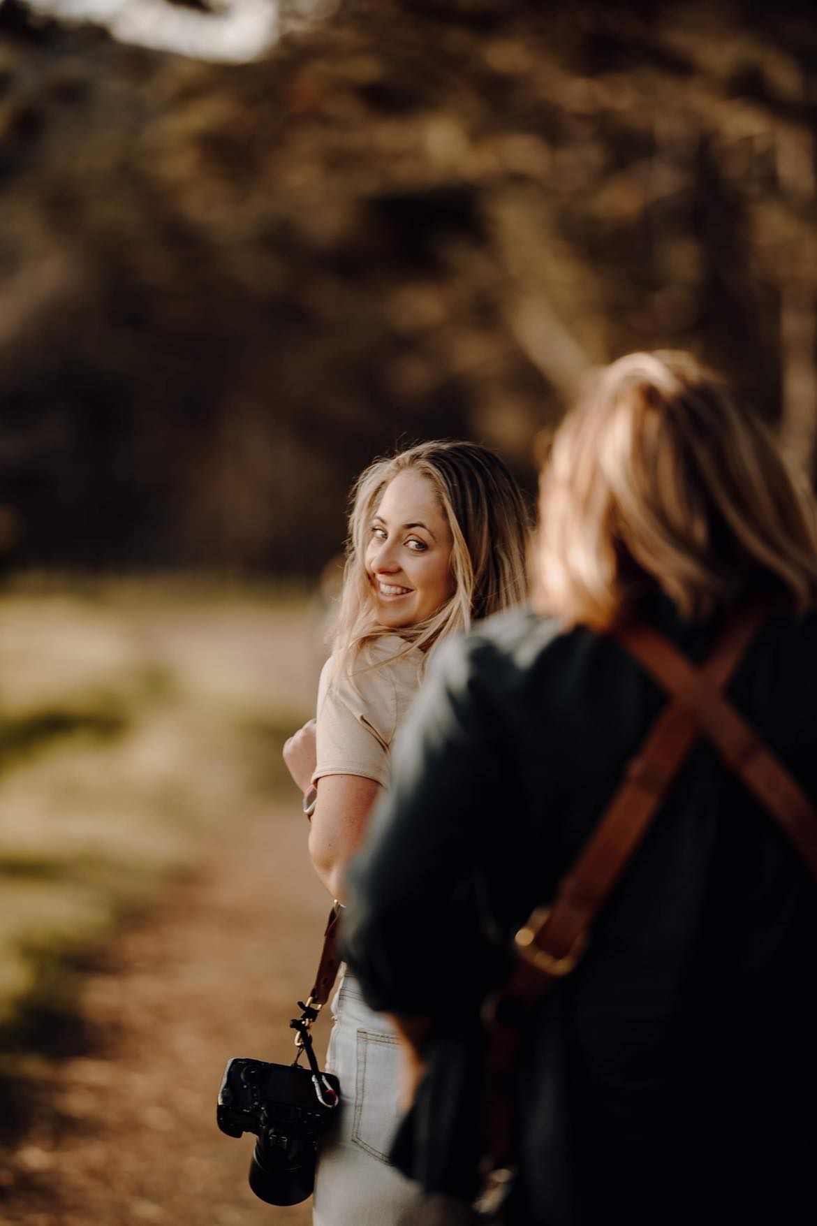 Candid moment of photographer and subject sharing a joyful interaction outdoors.