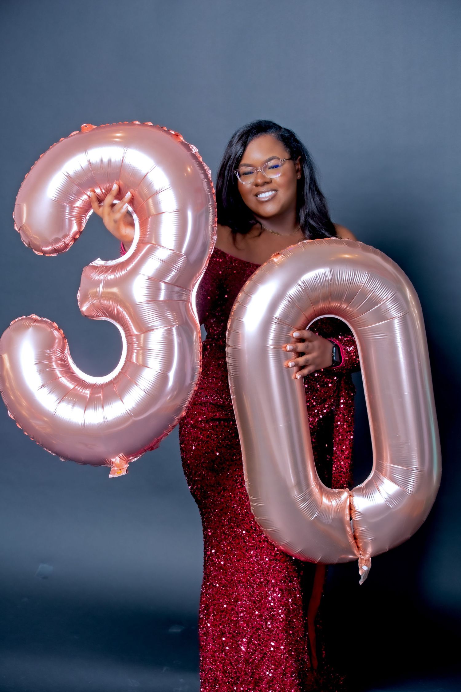 30th birthday celebration with rose gold number balloons and sparkly dress.