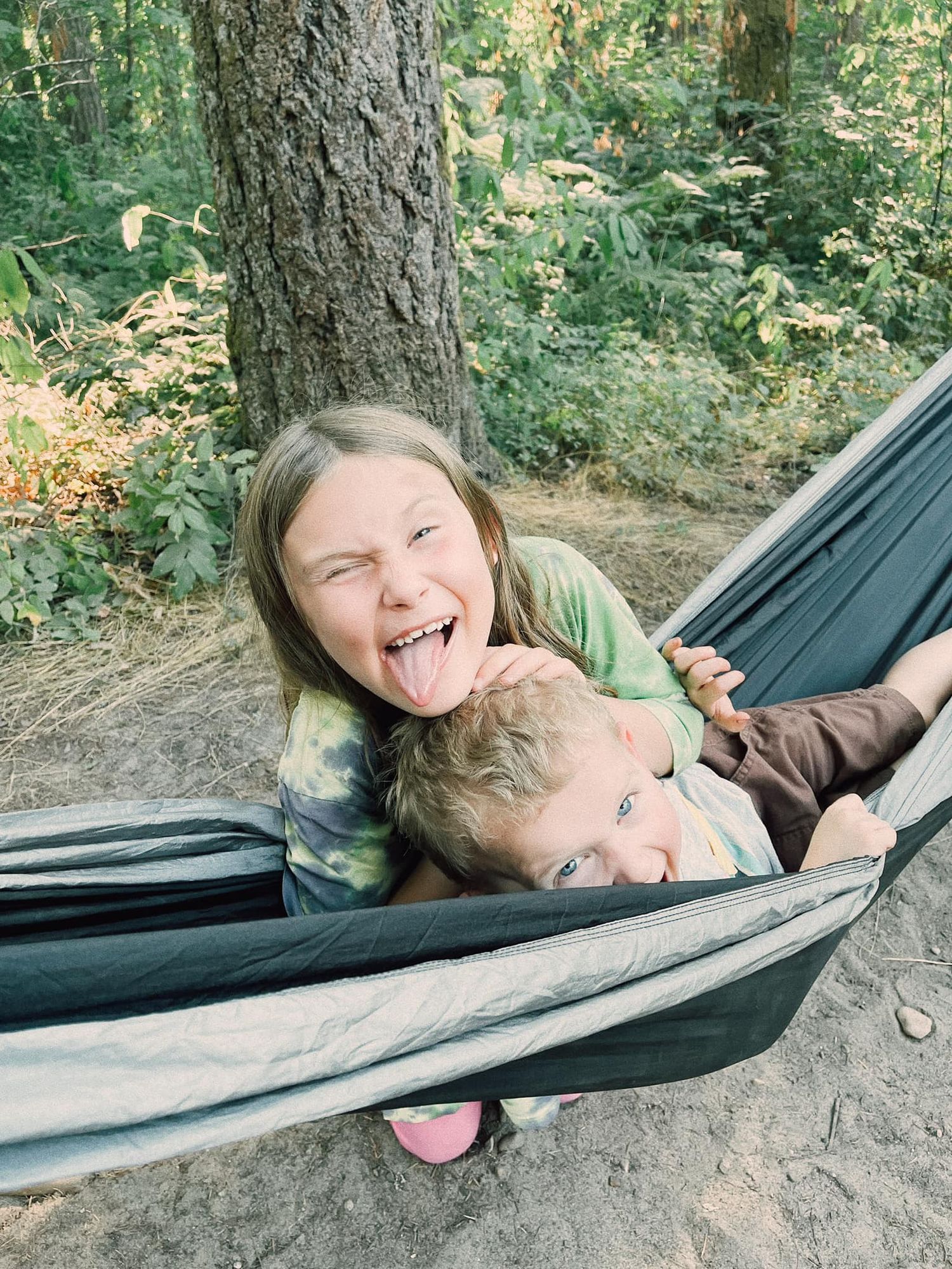 two kids smiling in hammock