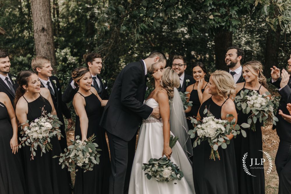 Wedding party poses outdoors with green foliage and natural bouquets.