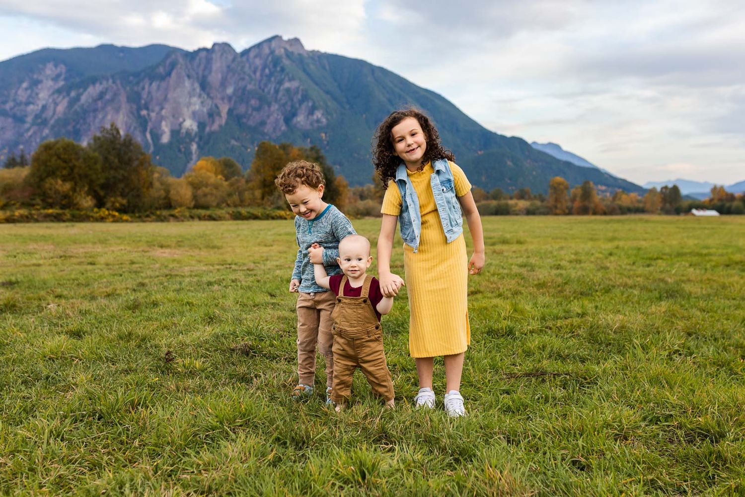 Three kids holding hands in North Bend, in front of Mt. Si.