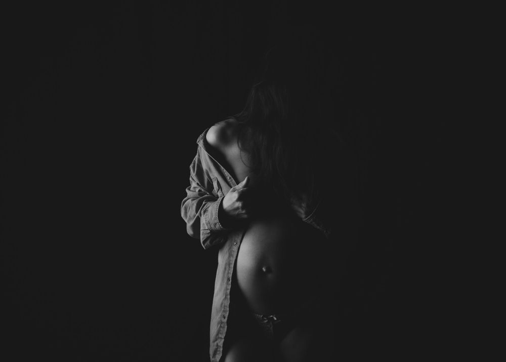 Dramatic black and white side profile portrait in dark lighting.
