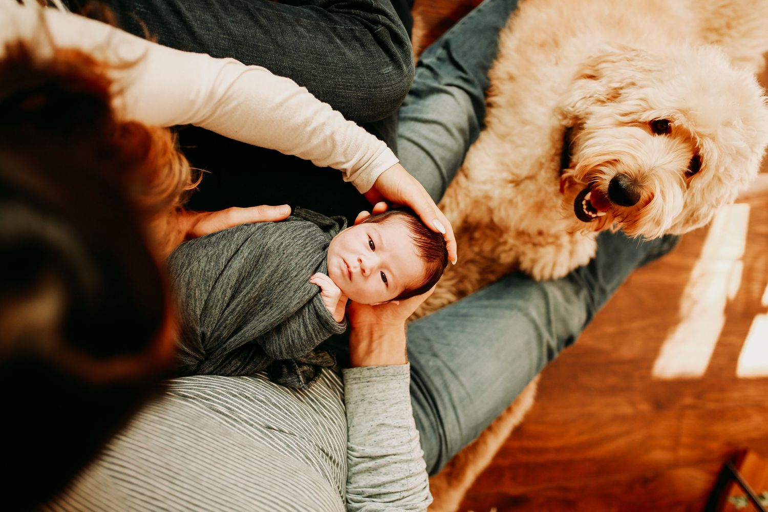 Lifestyle photography session on wooden floors with cozy lighting.