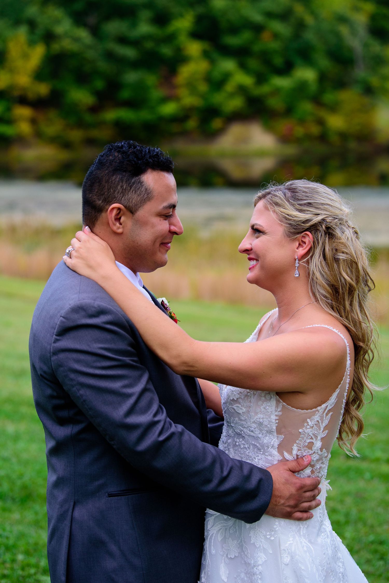 A series of candid wedding photos showing a couple dancing and laughing together on a grassy field.