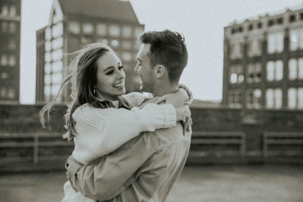 A romantic black and white photo series of a couple embracing against an urban backdrop.