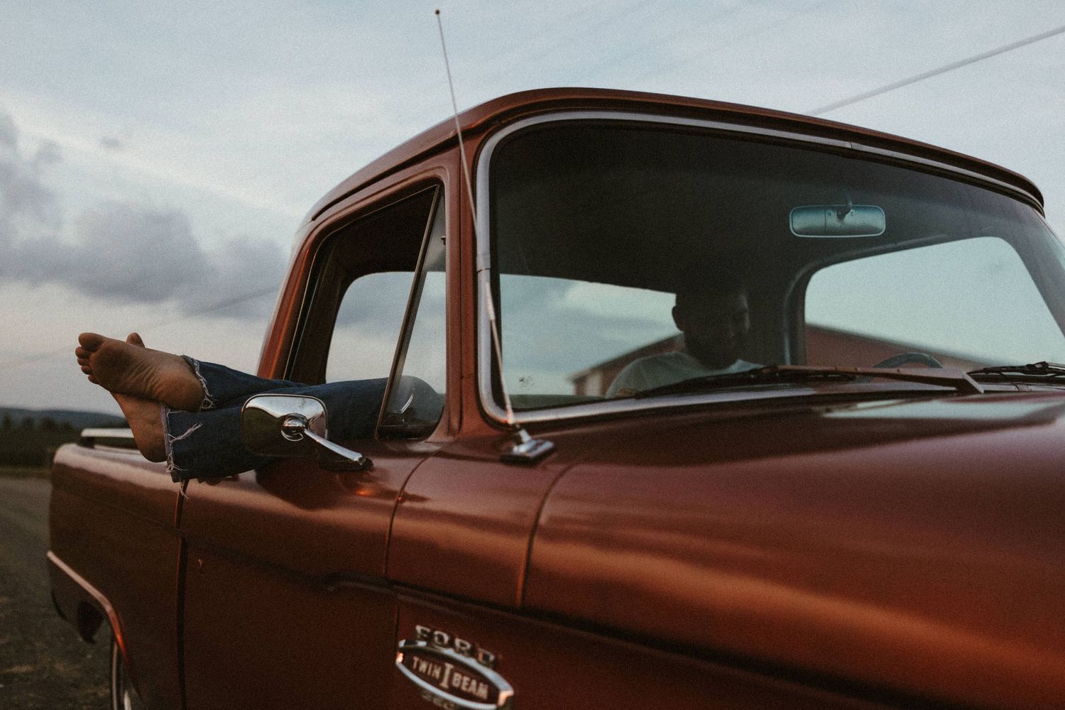 feet sticking out of a 1966 Ford 100 Twin I-Beam Classic Pickup Truck