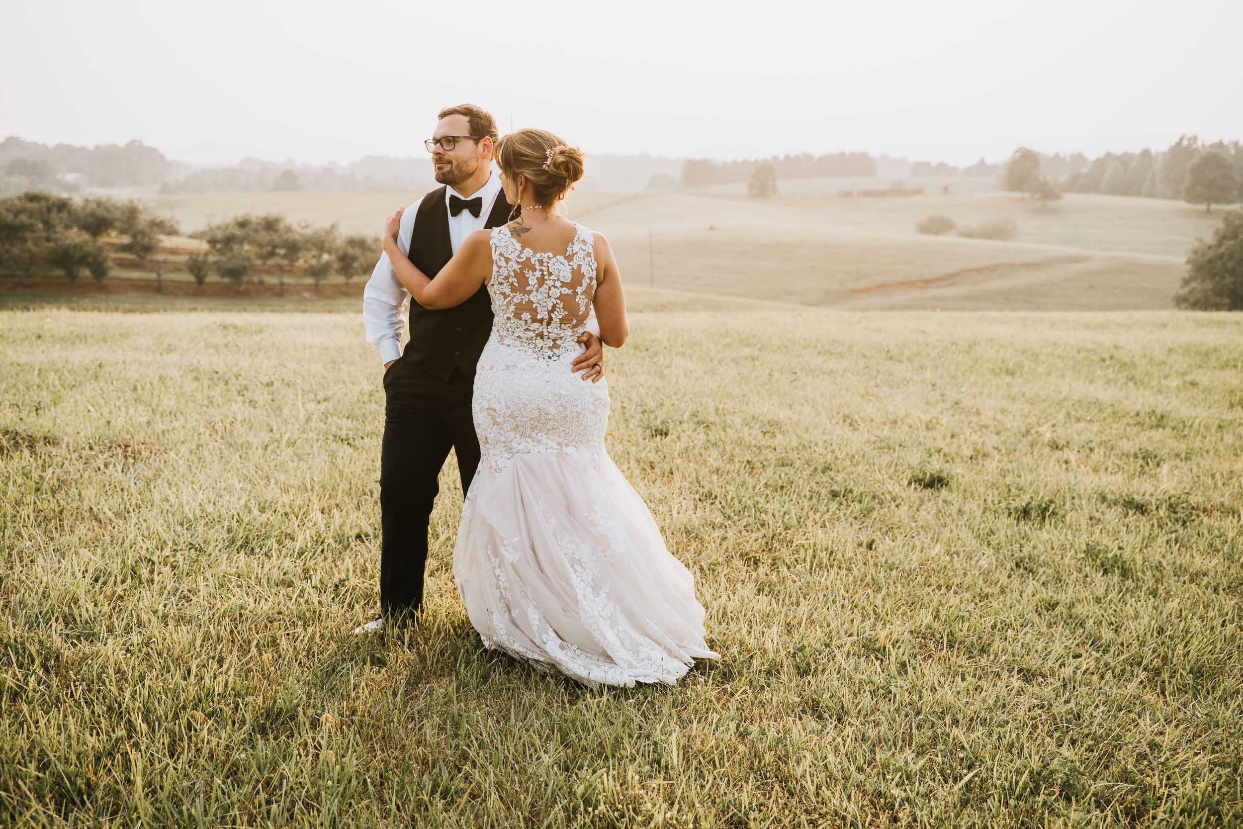 Couple poses for wedding photos in the vinyard at Chattooga Belle Farm during golden hour