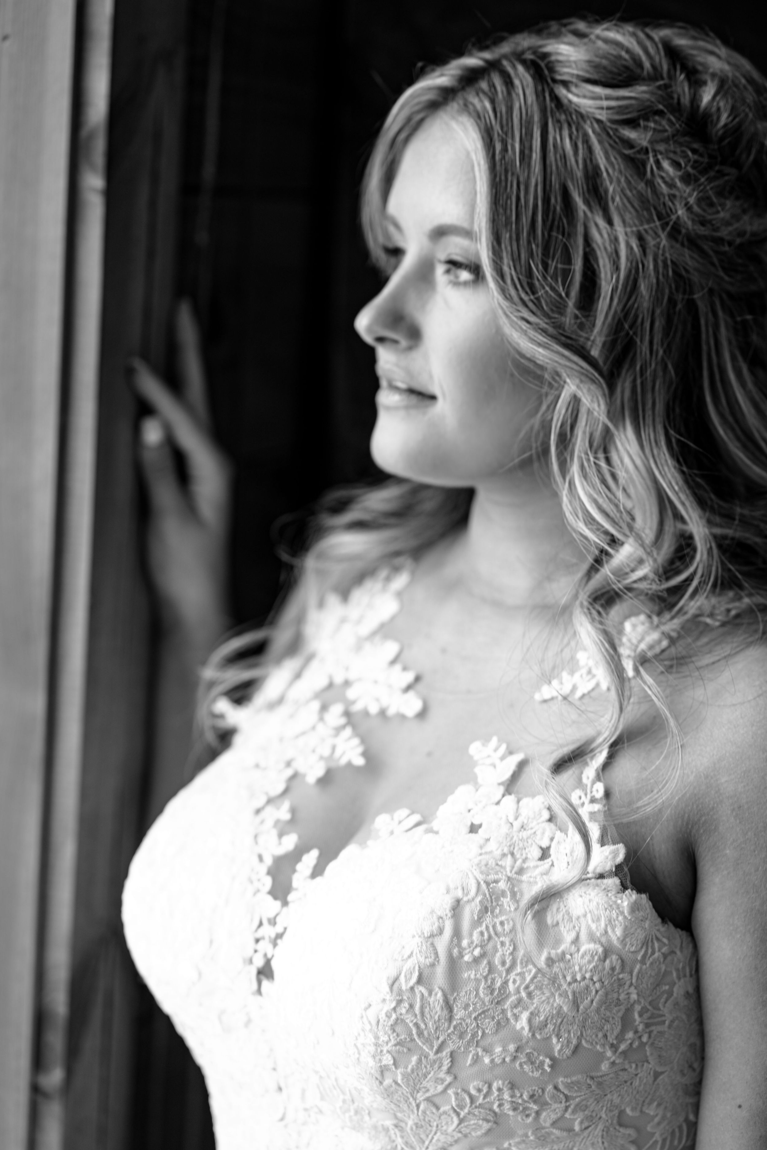 Beautiful bride stares out the window before her wedding ceremony at Hidden Acres in Gillsville Georgia