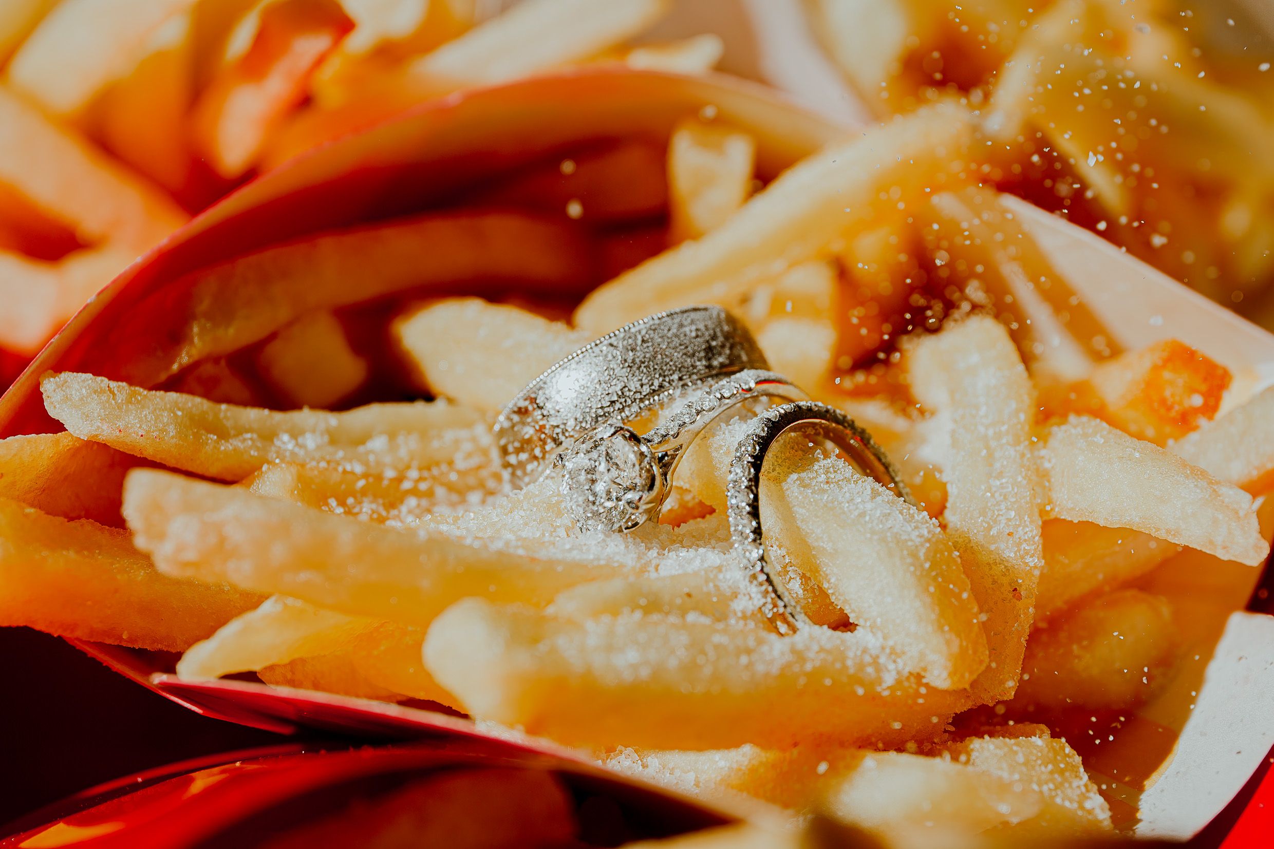 Close-up macro shot of crispy golden french fries with salt sprinkled on top.