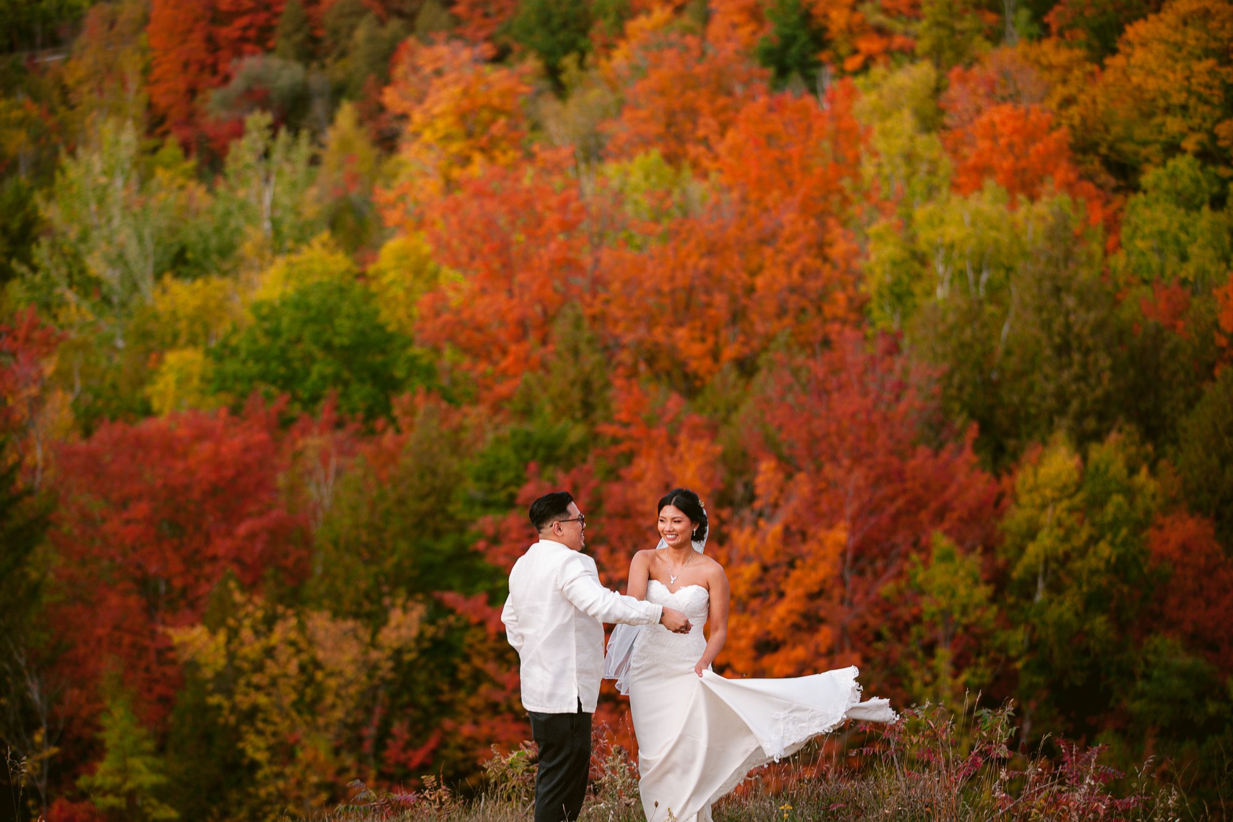 Wedding couple sharing a romantic moment amid stunning fall colors.
