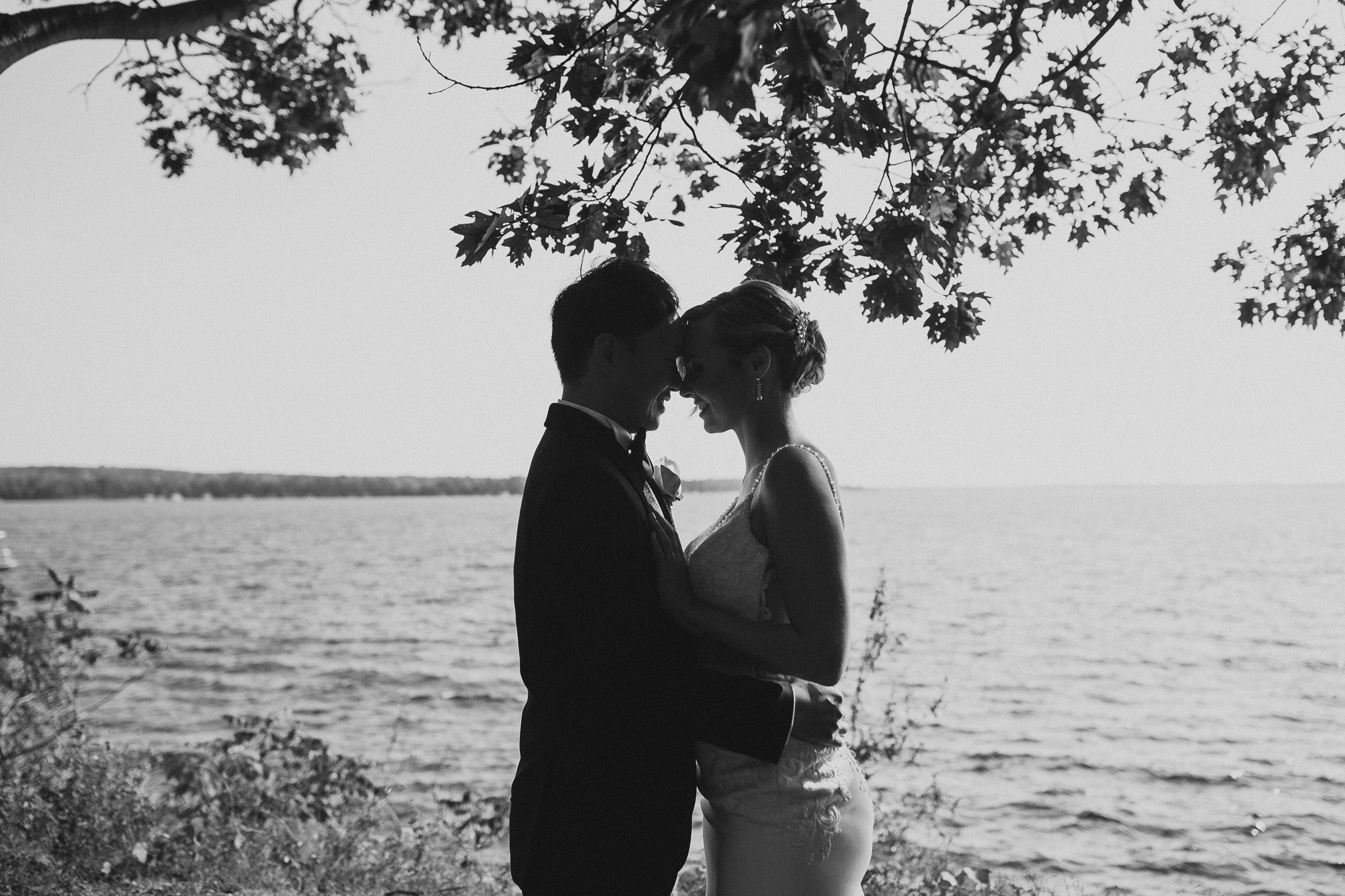 Romantic silhouette of a couple by the water at sunset.