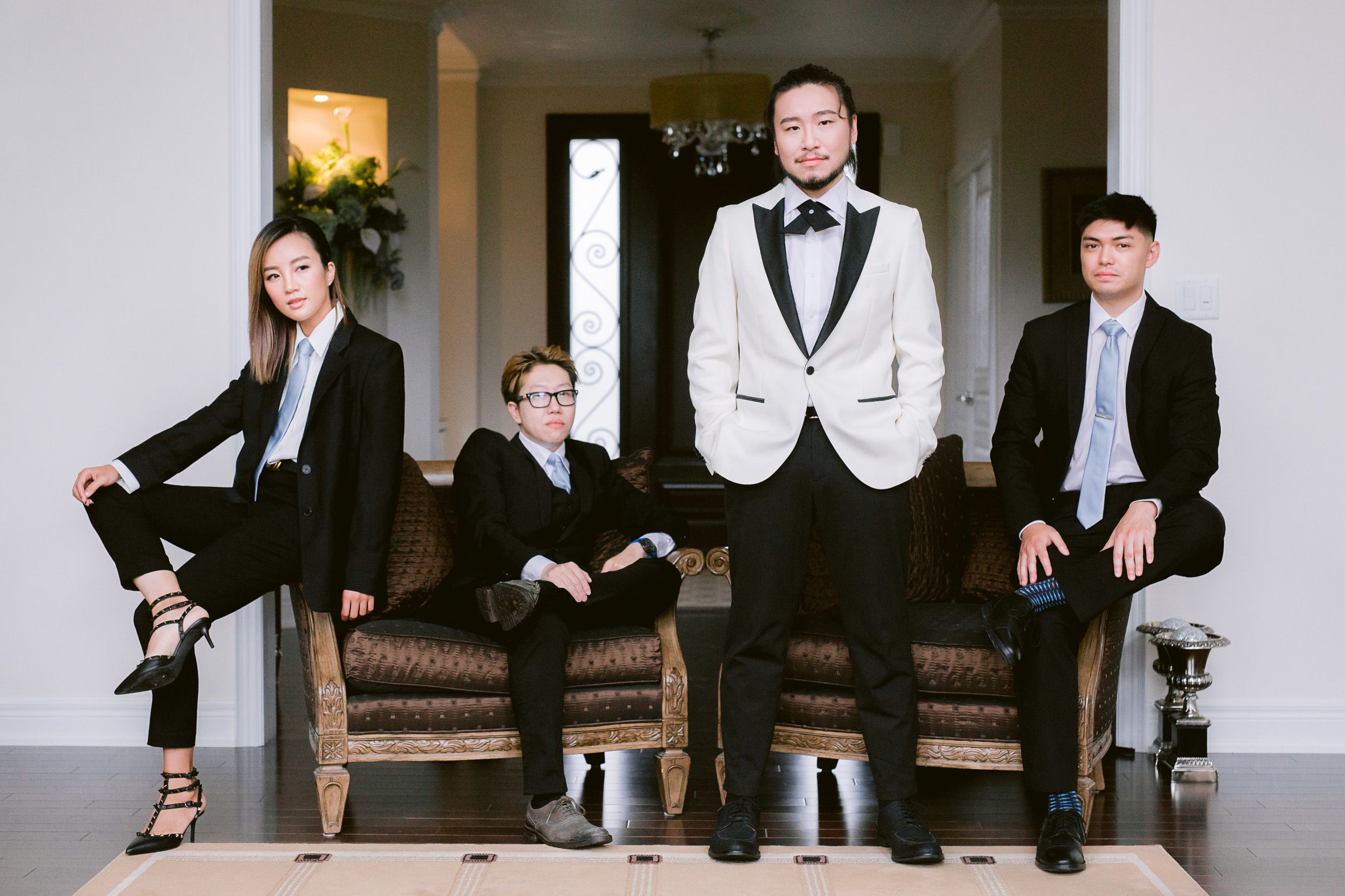 Wedding party in formal attire poses stylishly on vintage furniture.