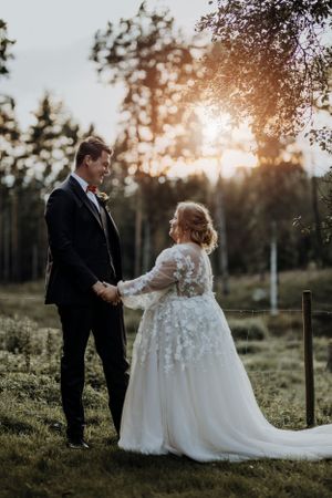 Couple shares romantic moment at sunset in outdoor wedding venue.