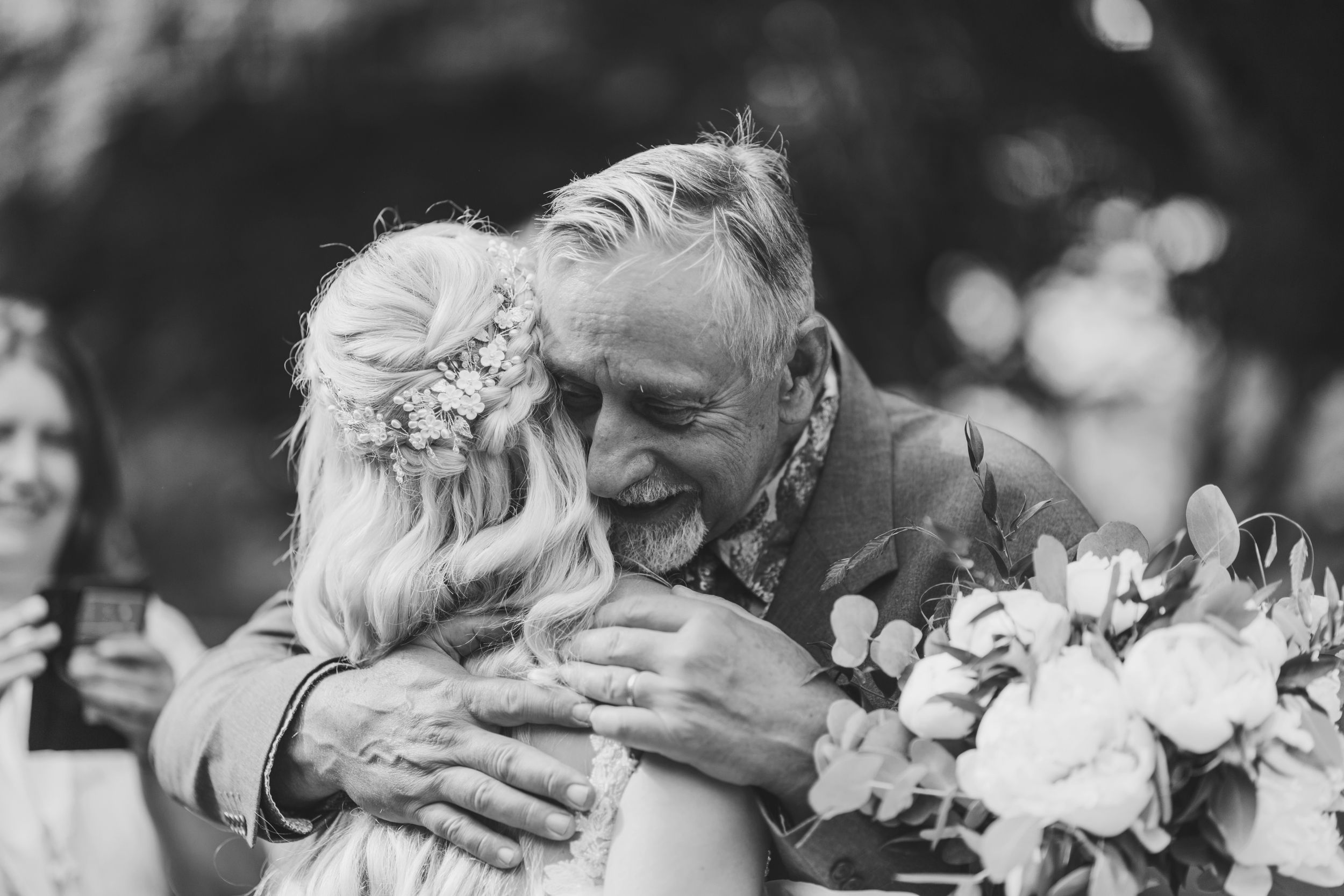 Black and white emotional embrace captured during wedding celebration.