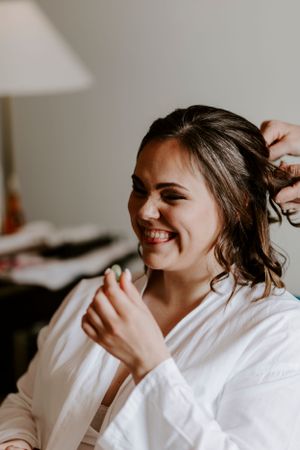 Getting ready portrait of someone in a white robe with a joyful expression.