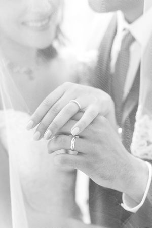 seance photo de mariage en couple en noir et blanc, la photo met en avant les alliances portes aux doigts