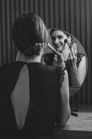 Black and white images of two people having a conversation across a table with wood paneling.