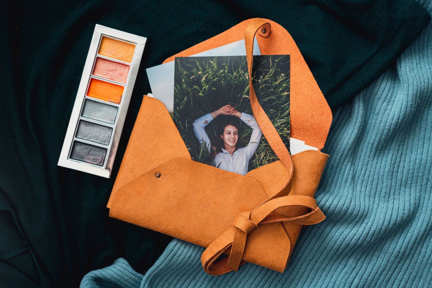 An orange fabric wrap with a photo and watercolor palette on teal fabric.