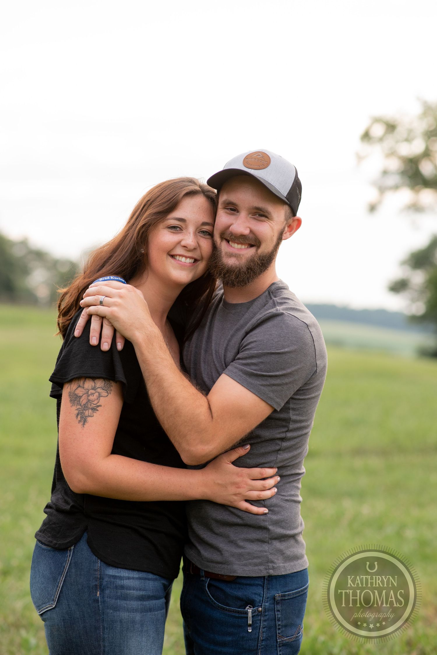 A happy couple embracing outdoors with matching casual outfits.