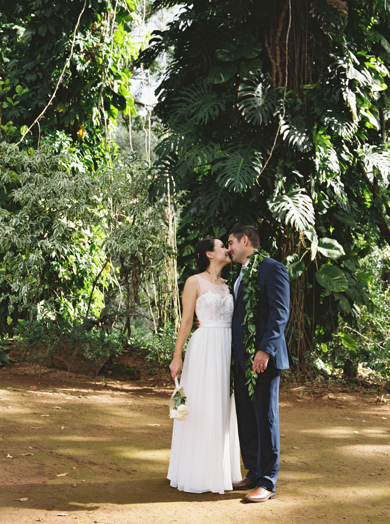 Wedding couple standing nose to nose in a forest at Sunset Ranch, North Shore Oahu