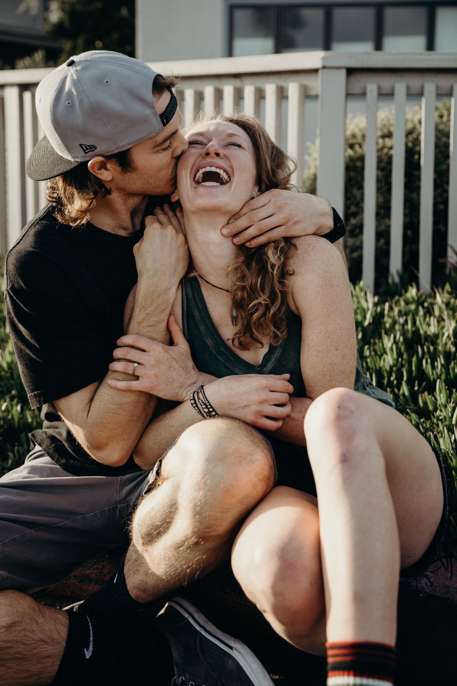 A candid moment of affection and laughter captured on a skateboard deck.