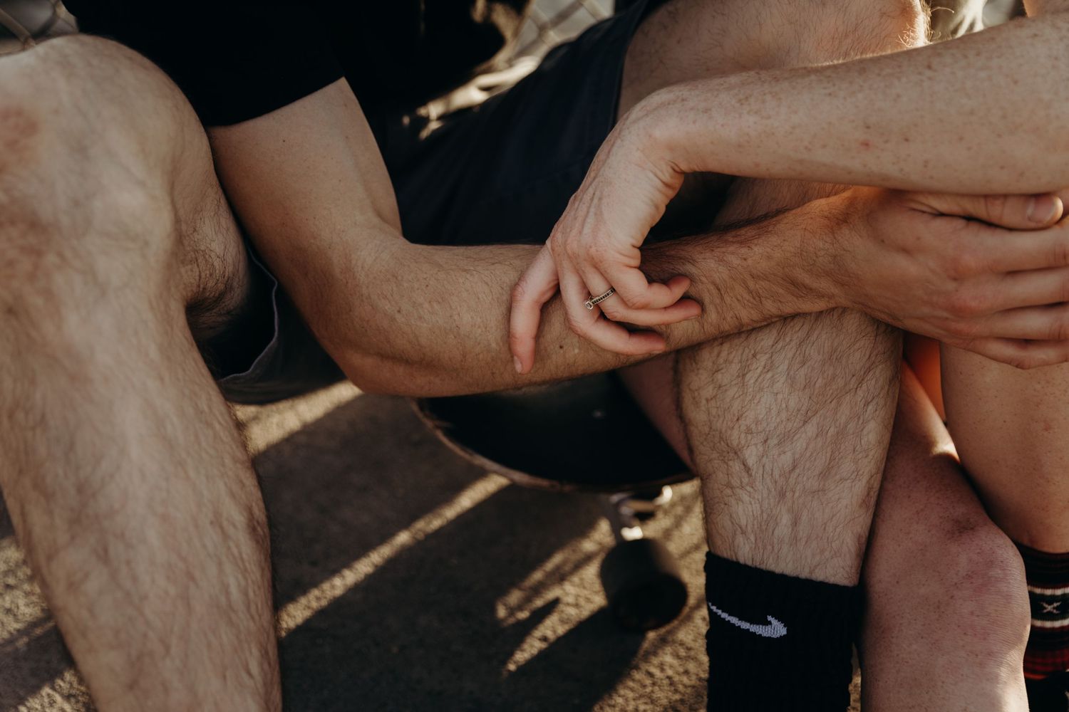 Close-up shot of couple's legs wearing black athletic socks and shorts.