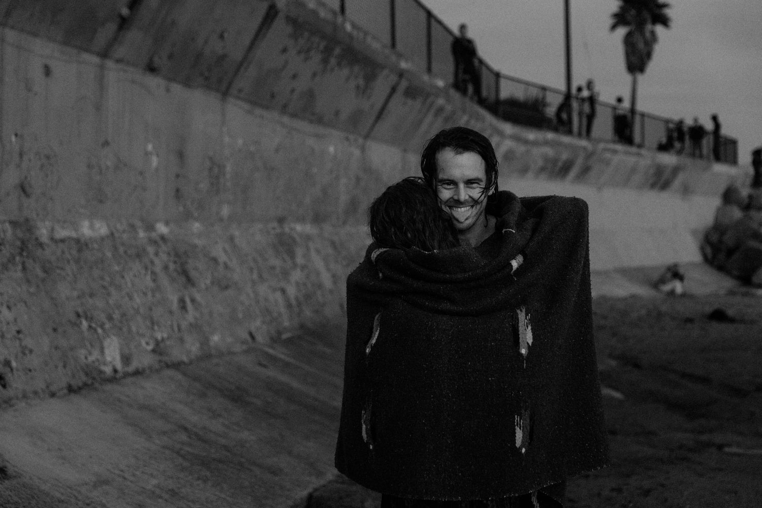 Black and white portrait taken against a concrete wall outdoors.