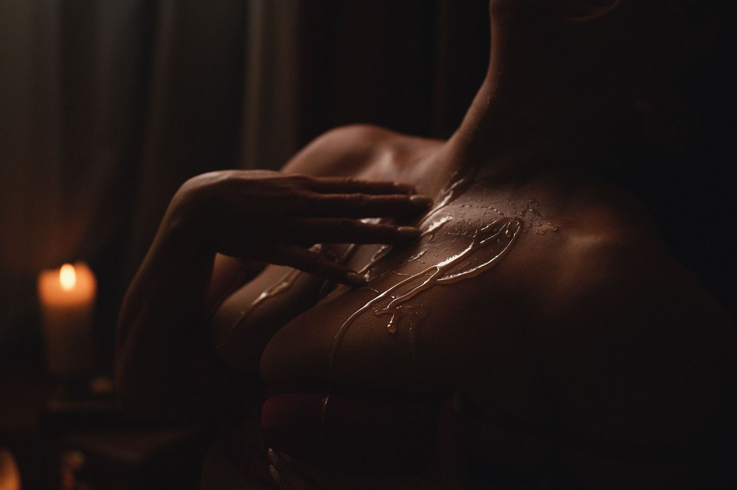 Silhouetted hands create artistic shadows against candlelit background.