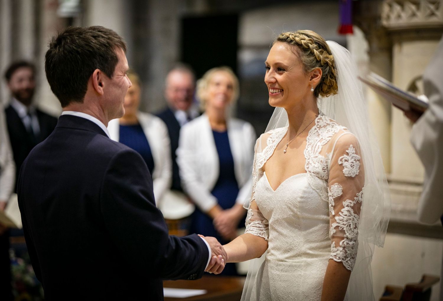 Wedding ceremony in progress inside historic cathedral with ornate stone architecture.