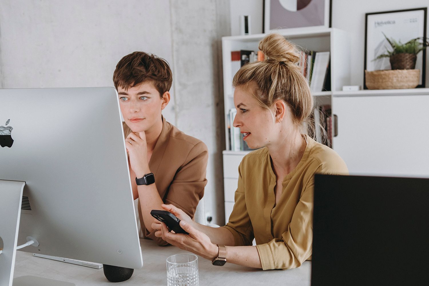 People working together at computers in a modern office space.