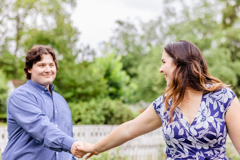 Couple shares playful moment in garden while wearing coordinating blue outfits.