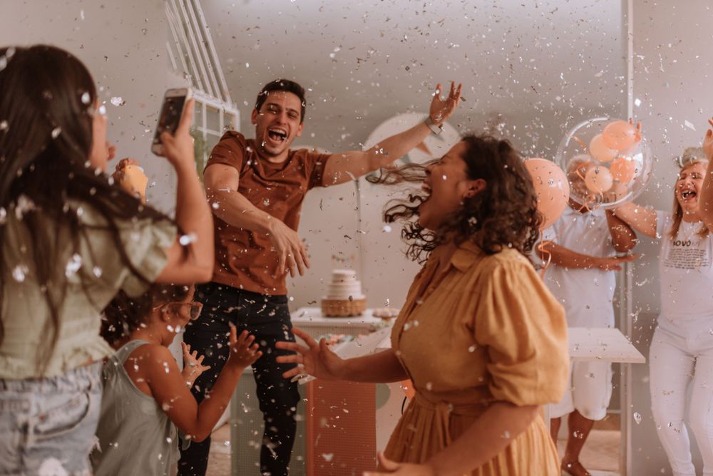 Joyful celebration with confetti flying through the air at an indoor party.