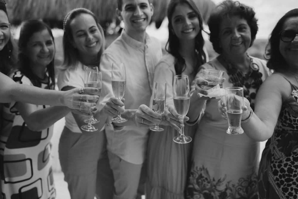 Group toasting with champagne glasses at outdoor celebration in black and white.