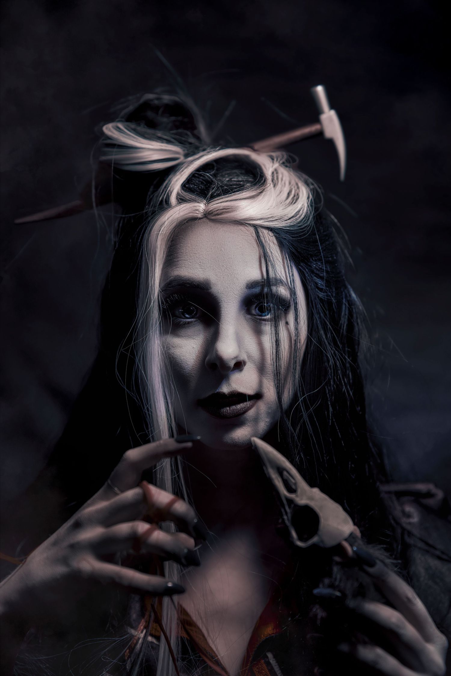 Dark gothic portrait with dramatic lighting and contrasting black and white tones against a moody background.