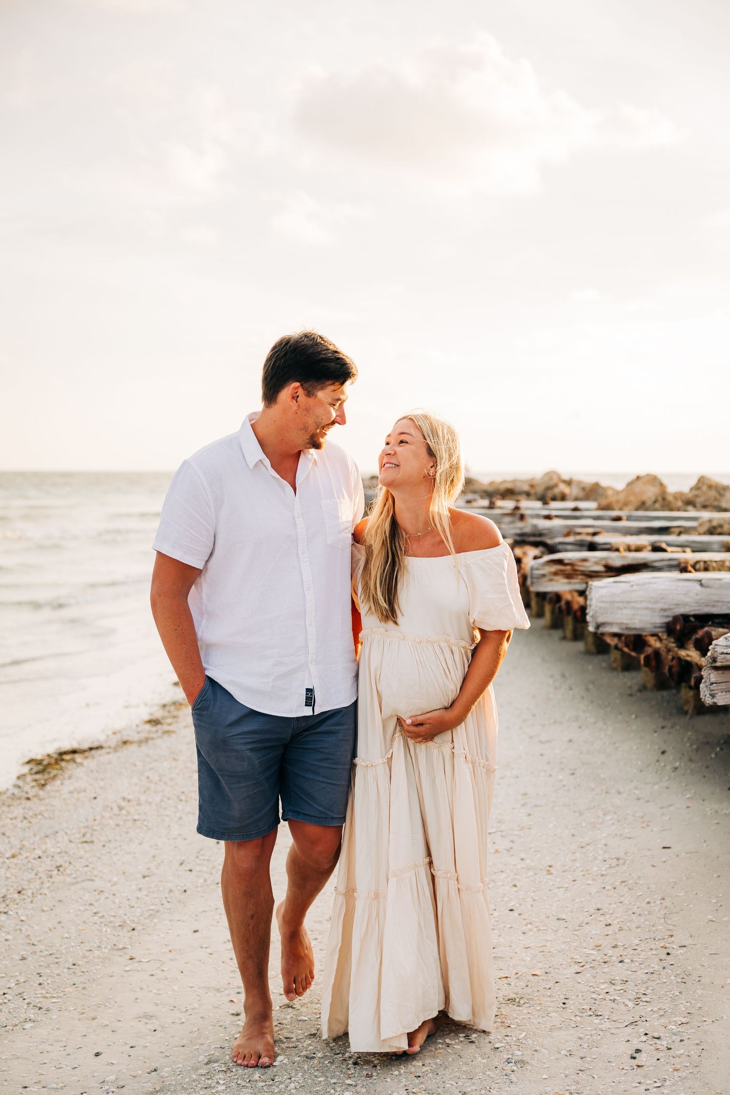 Mom to be walking on Coquina Beach on Anna Maria Island, FL hand in hand during their Maternity Session.