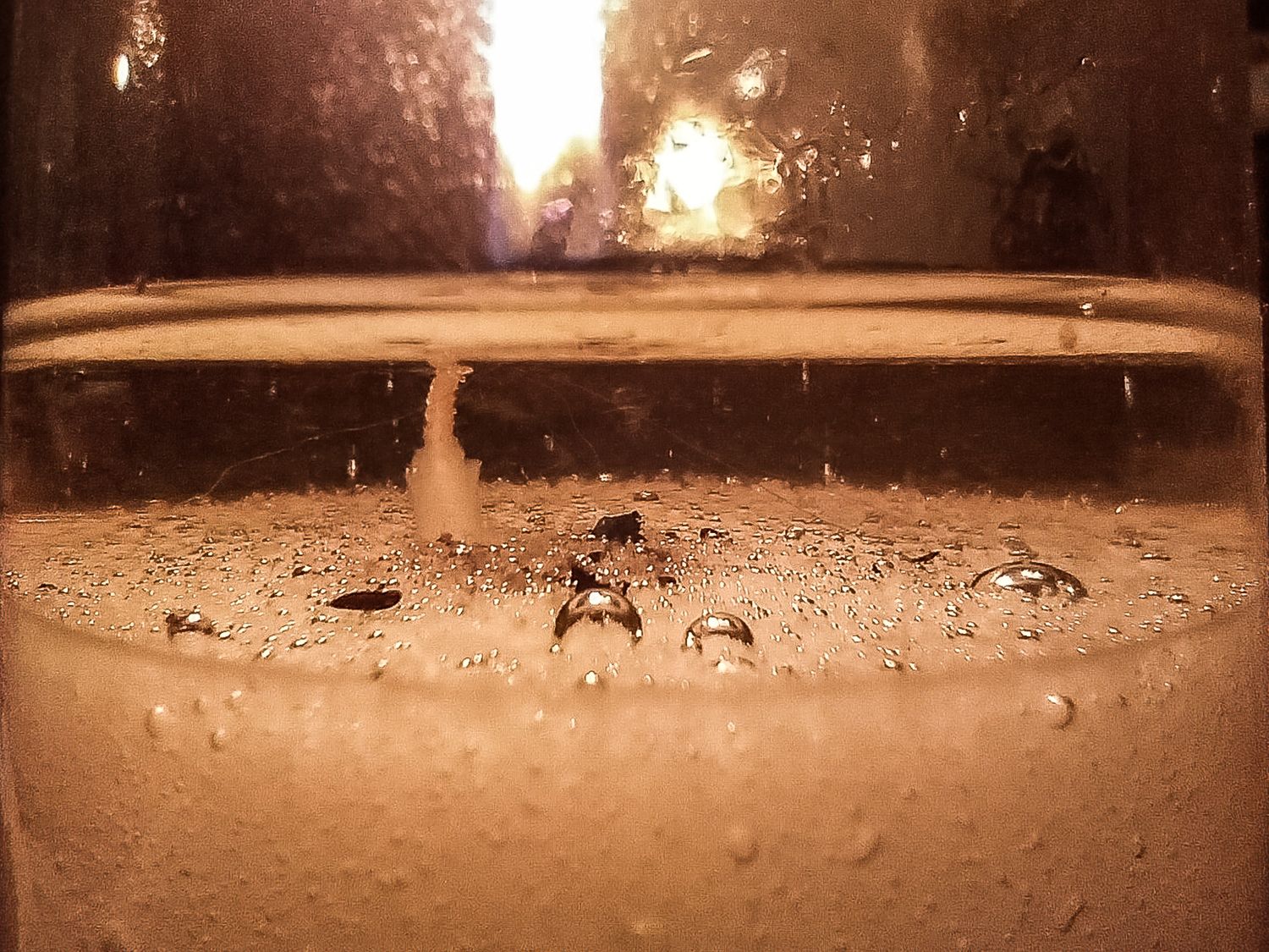 Macro photograph of bubbles in amber liquid with dramatic backlighting effects.