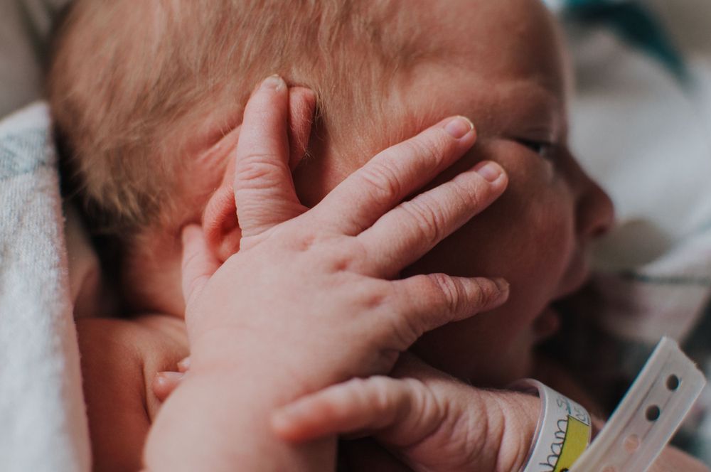 Tiny newborn fingers resting on newborn at CHI St. Alexius Hospital in Dickinson, ND - Fresh 48 photographer serving Dickinson, ND