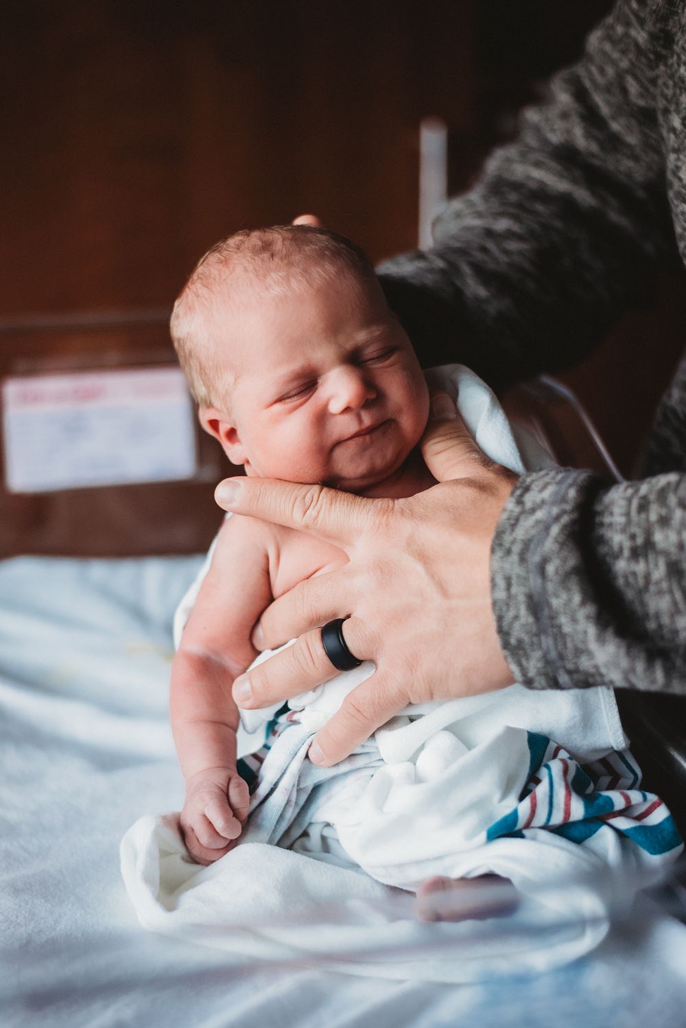 Dad burping newborn baby during Fresh 48 session - natural light photographer serving Dickinson, ND hospital