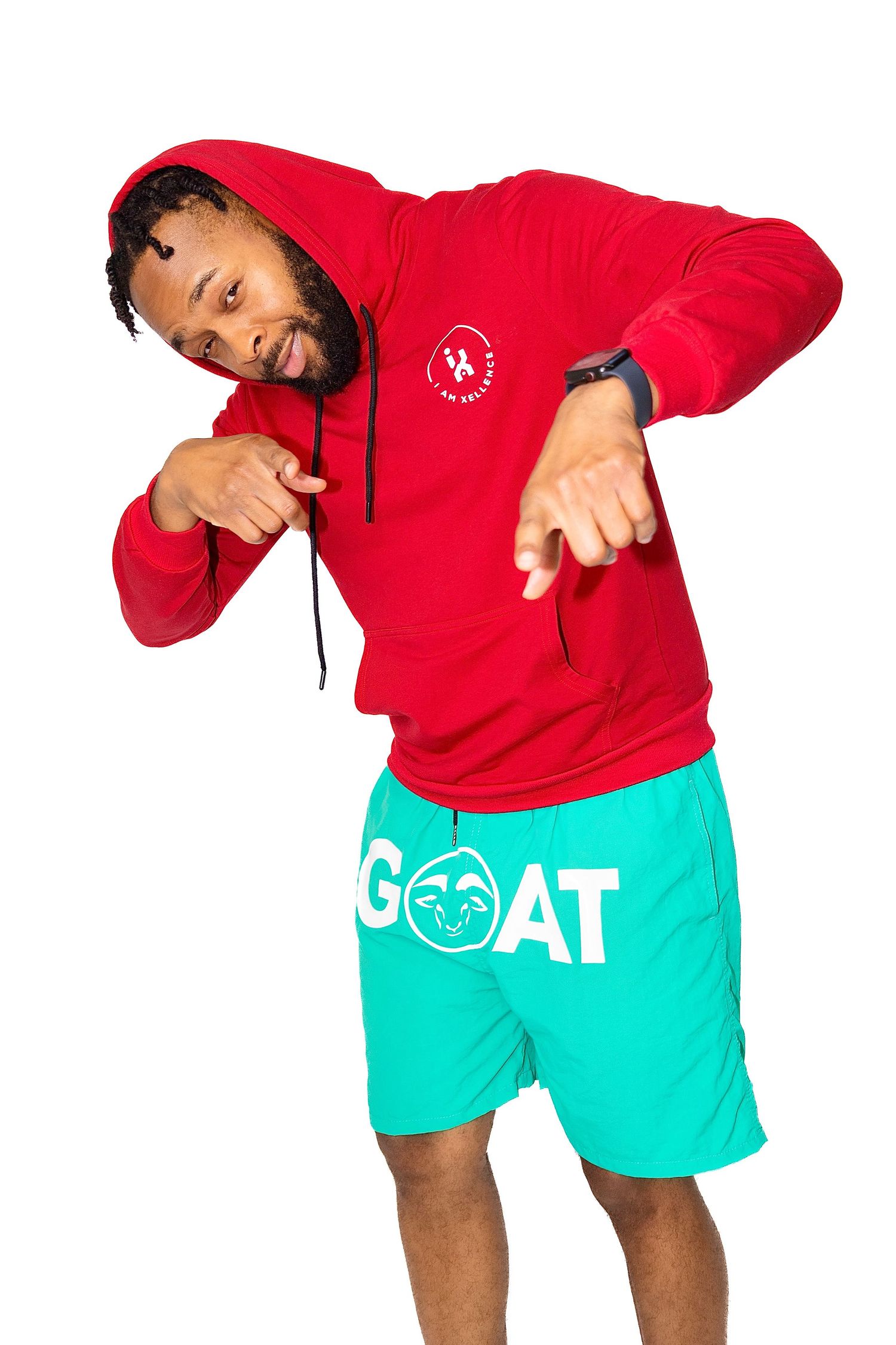 Person wearing red hoodie and teal shorts with GOAT logo in playful pose.