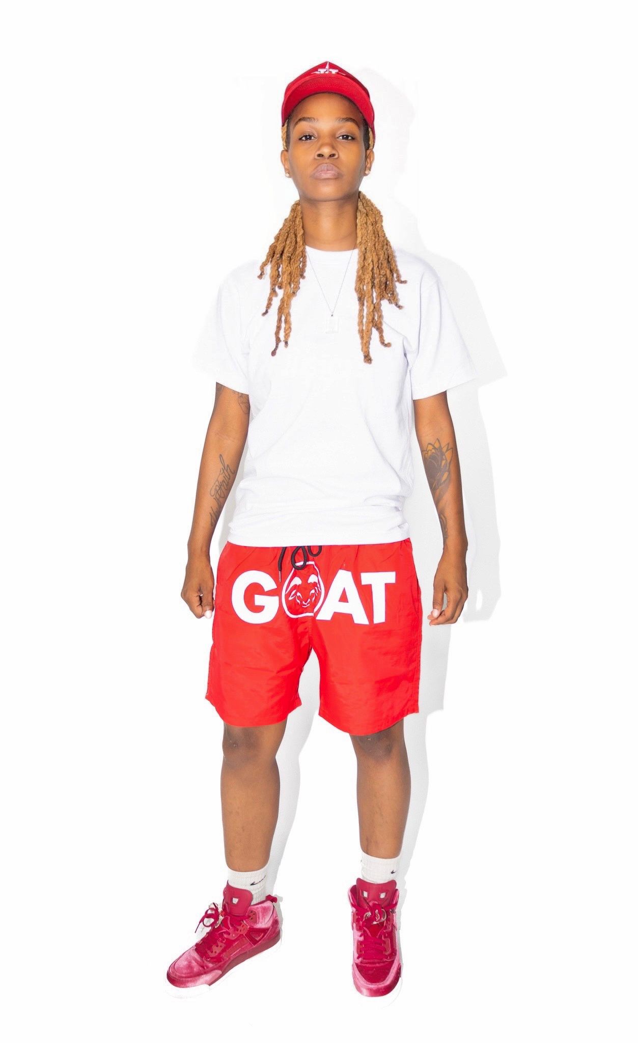 Casual outfit with white t-shirt, red GOAT shorts, and matching red cap.