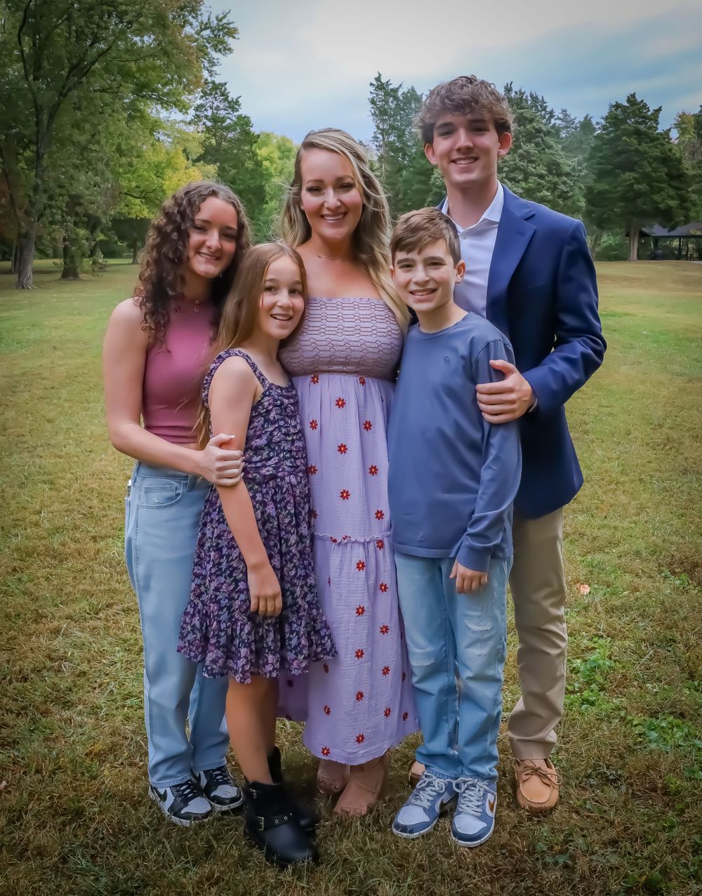 Group photo of family members in casual attire standing together on grassy field.