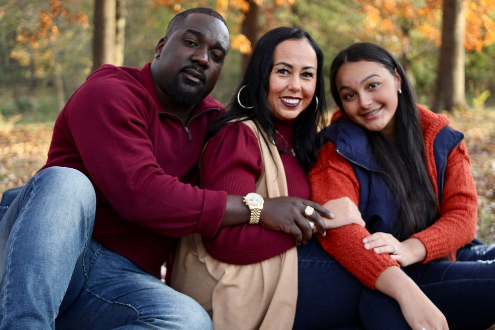 Family portrait session outdoors with warm autumn colors and casual styling.