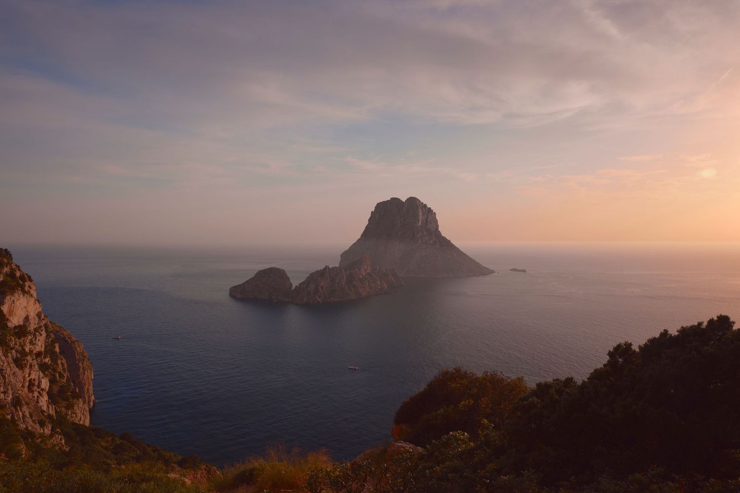 Majestic rocky island formation Es Vedra in Ibiza during golden sunset over Mediterranean Sea.