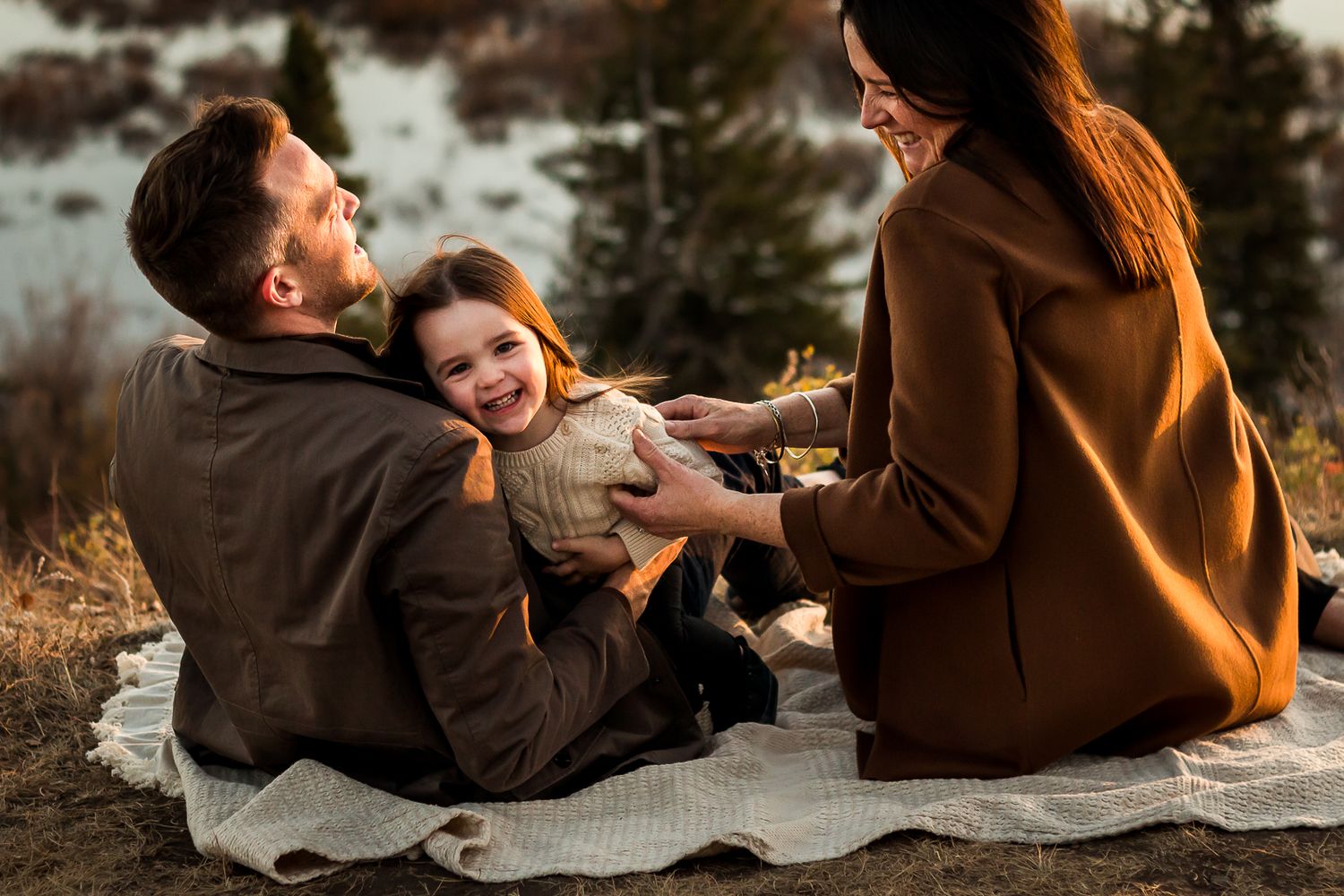 Family giggles during fall photo session at Glenmore Reservoir with Love & Sunshine Photography